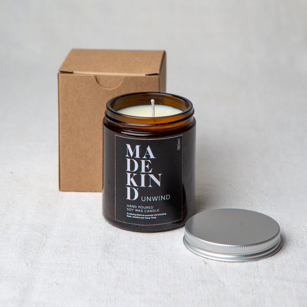 Candle with 'MADEKIND' label and packaging on a light background