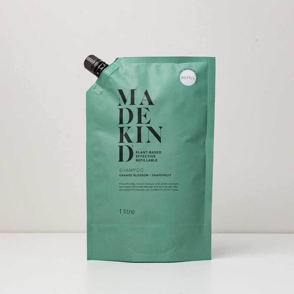 Green refillable shampoo pouch with 'MADEKIND' branding on a white background