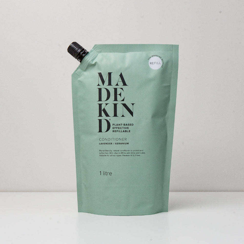 Green refillable conditioner packaging with 'MADE KIND' branding on a white background