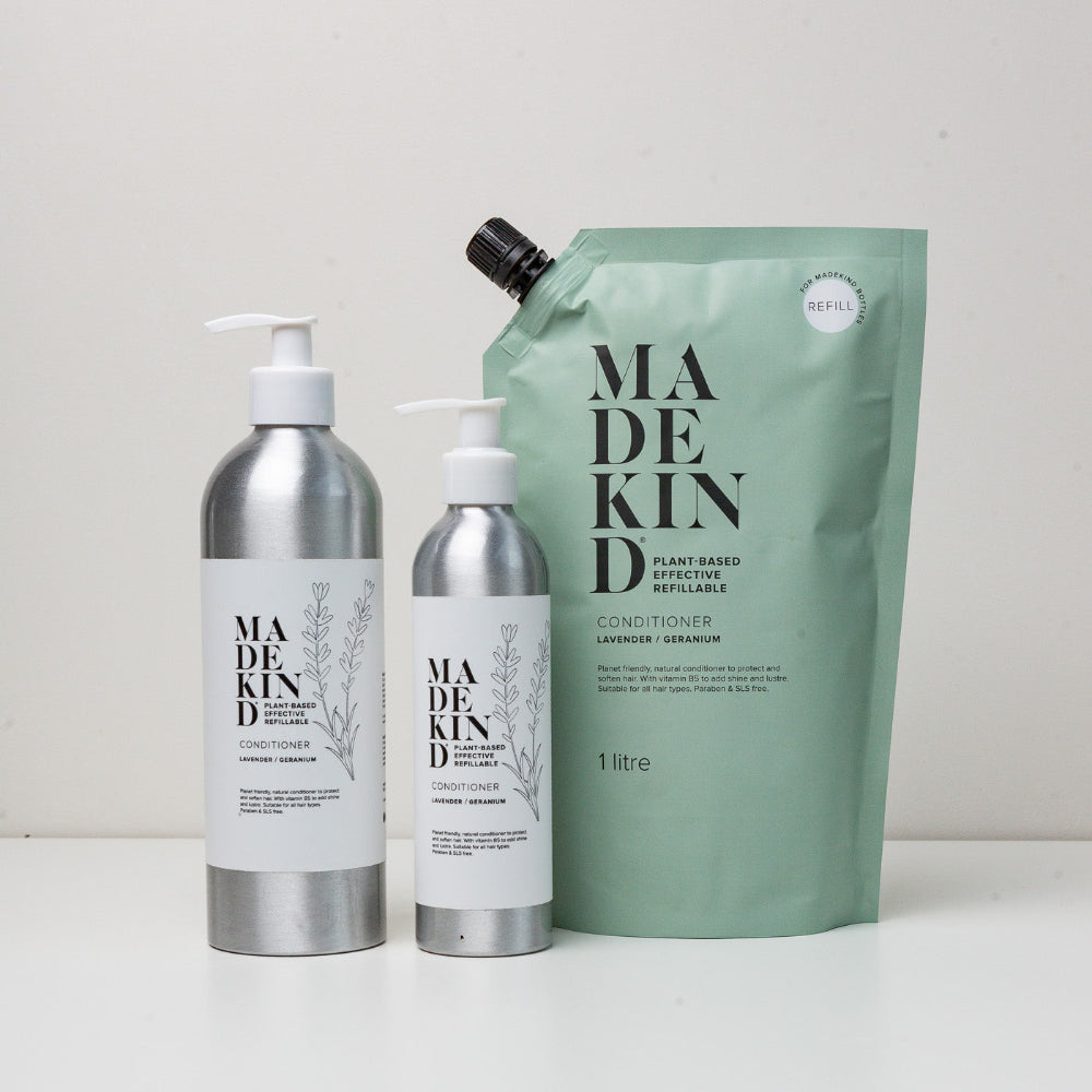 Made Kind hair care products including bottles and a pouch on a white background