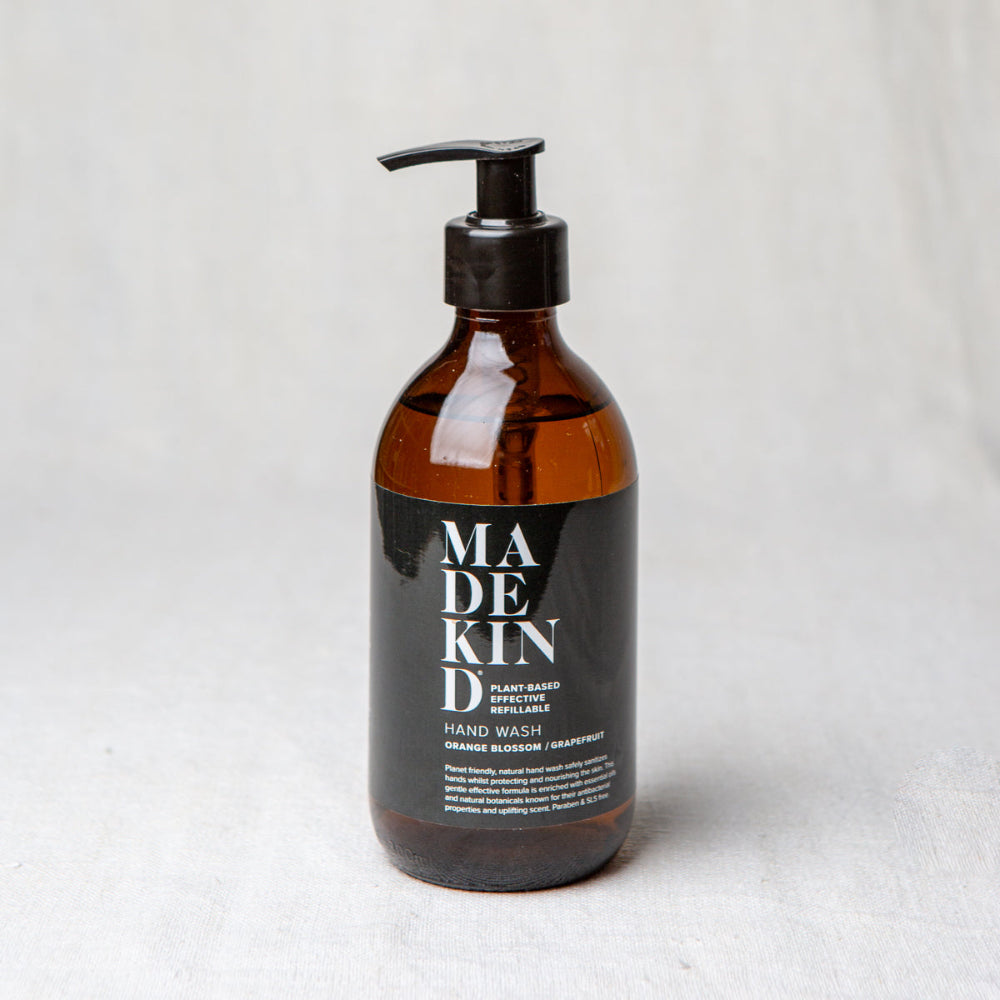 Brown bottle with black pump and 'MADE KIND' label on a light gray background Orange Blossom and Grapefruit
