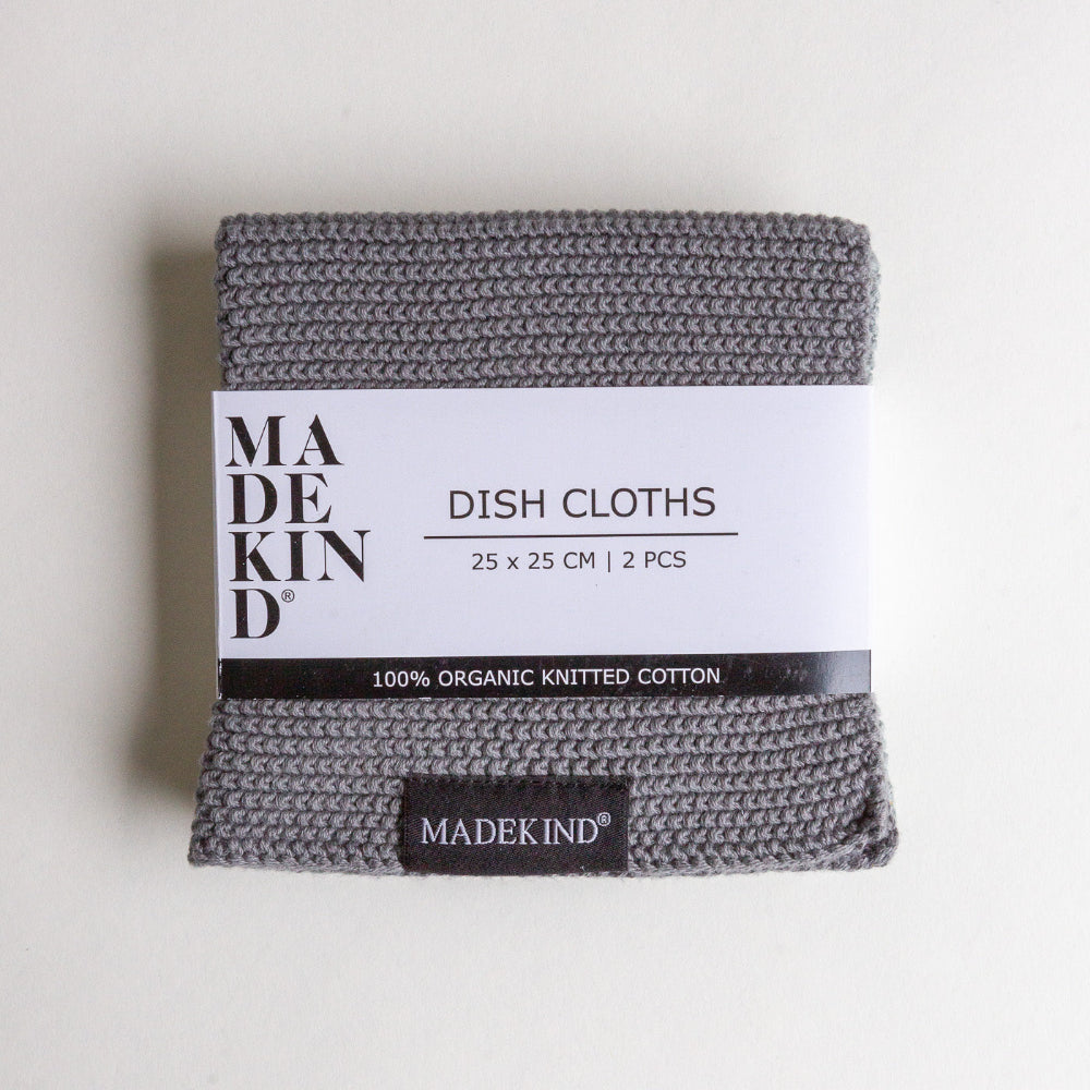 Pack of grey organic knitted dish cloths with 'MADEKIND' branding on a white background