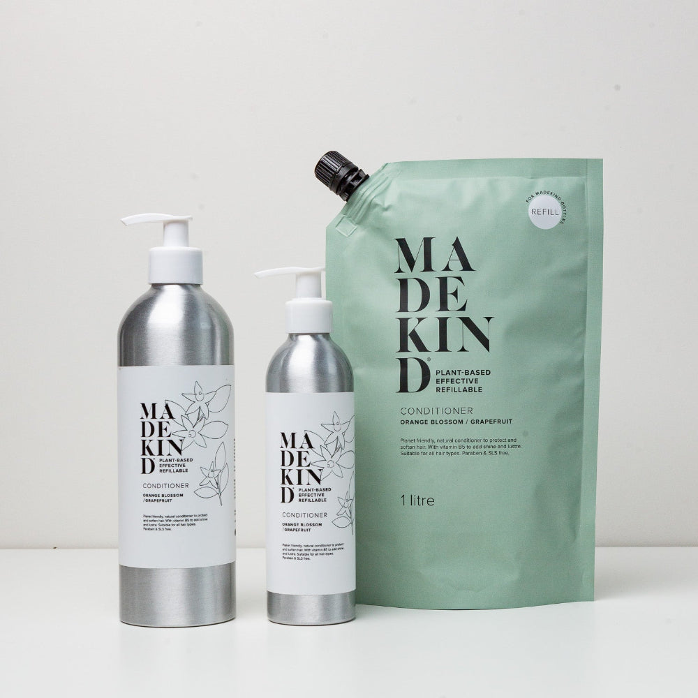 Madekind hair care products including a shampoo bottle, conditioner bottle, and a refillable pouch on a white background.