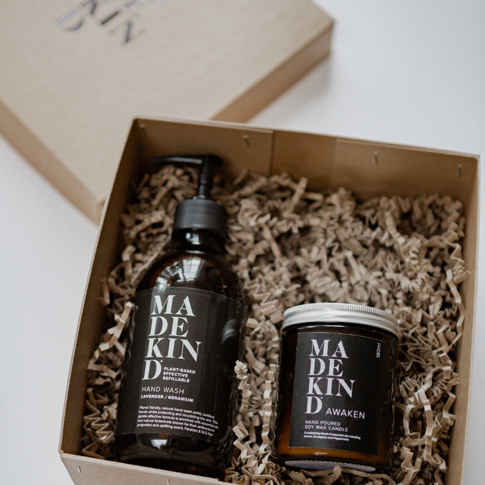 Two 'MADE KIND' products in a box with crinkled paper lining.