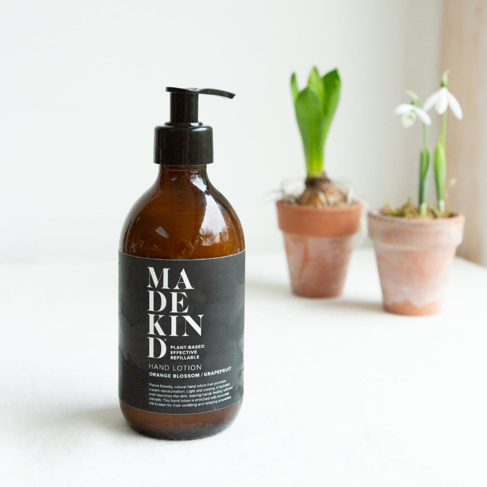 Bottle of Made Kind Orange blossom and Grapefruit hand lotion with plants in the background