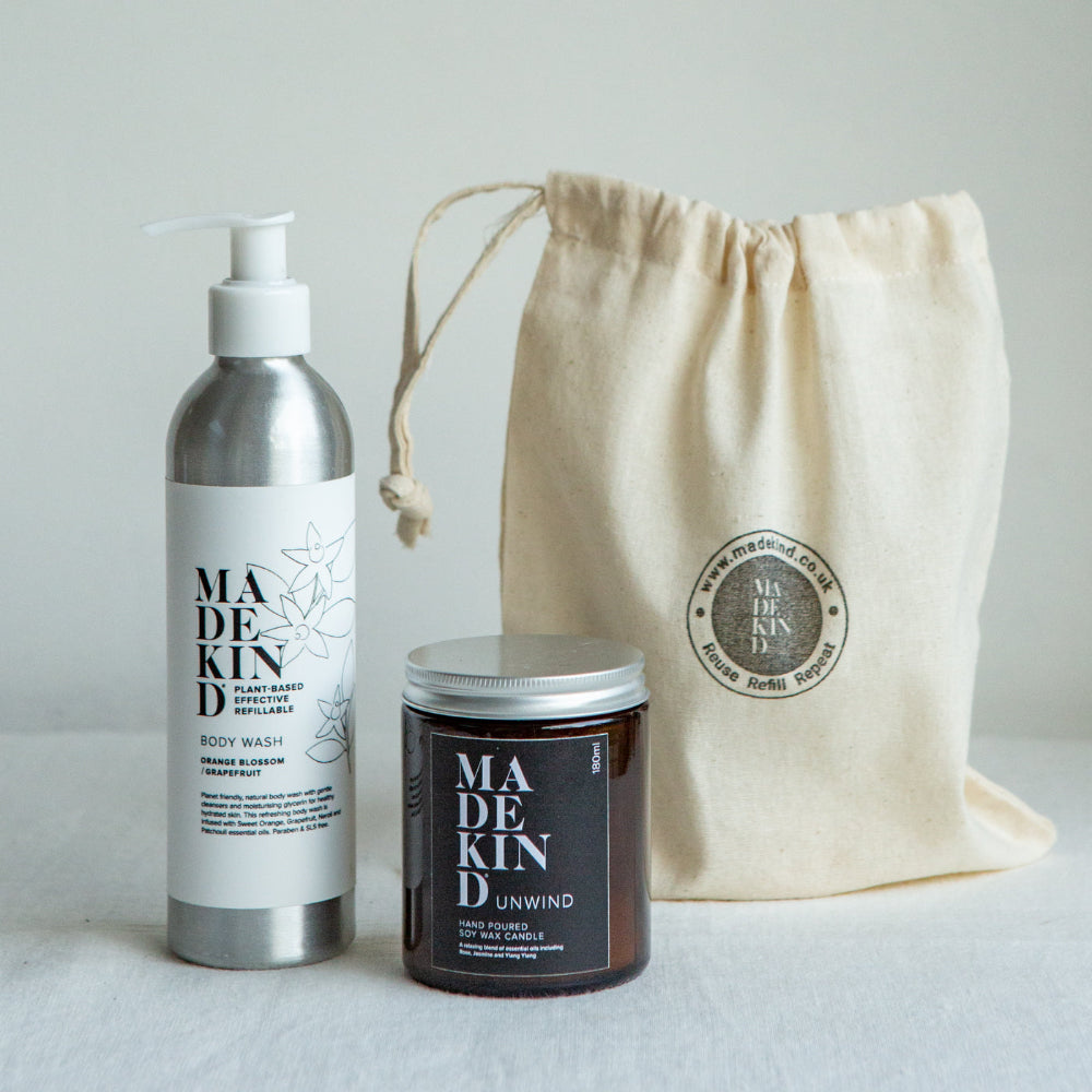 Body wash, candle, and drawstring bag with 'MADE KIND' branding on a light background