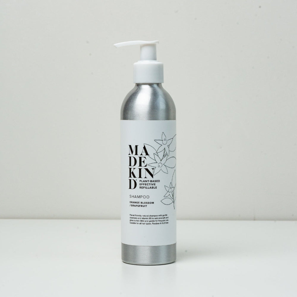 Silver and white Madekind shampoo bottle with pump on a light grey background