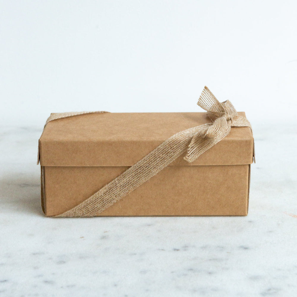 Madekind candles Brown box with a ribbon on a marble surface