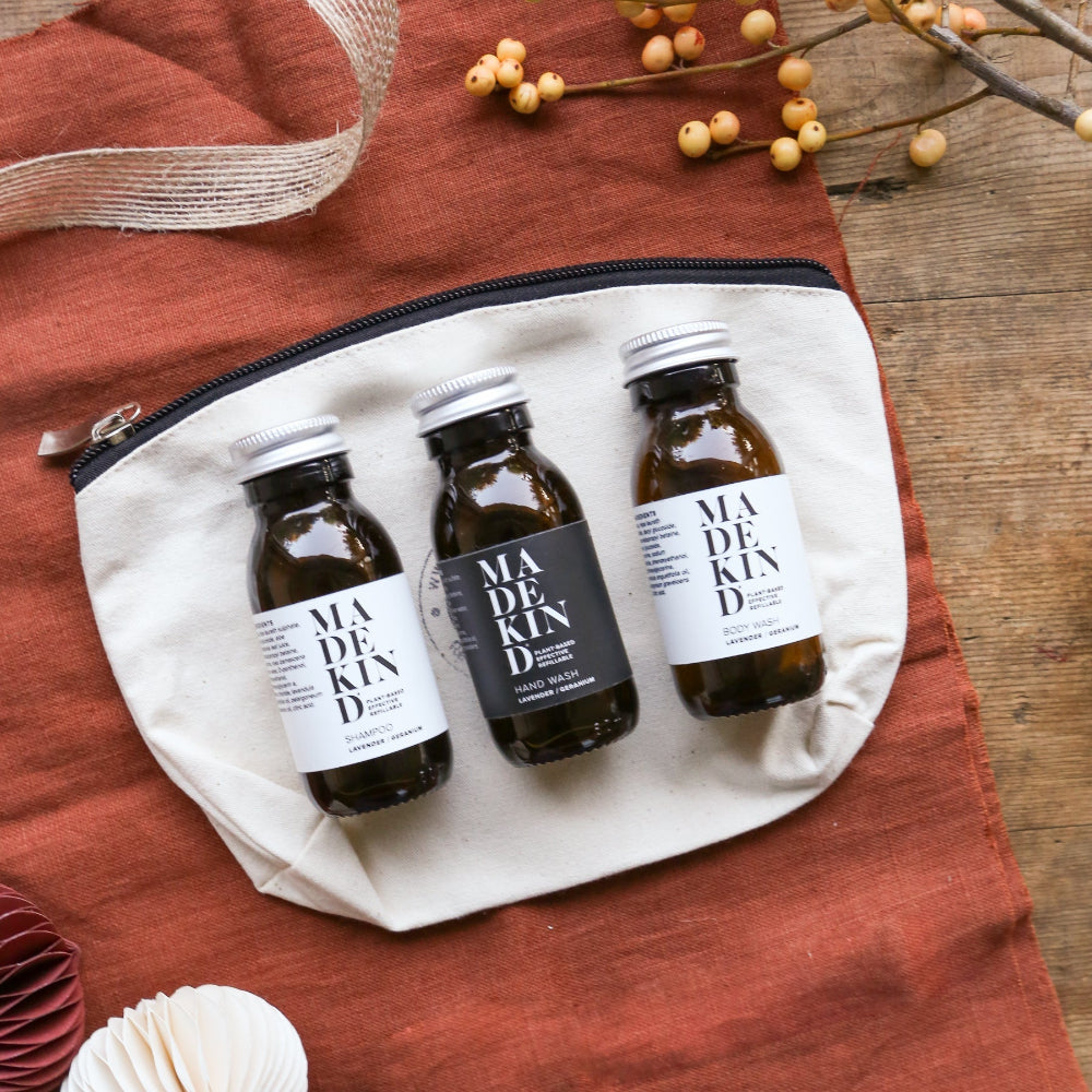 Three bottles of 'MADE KIND" on a white pouch with a rustic background