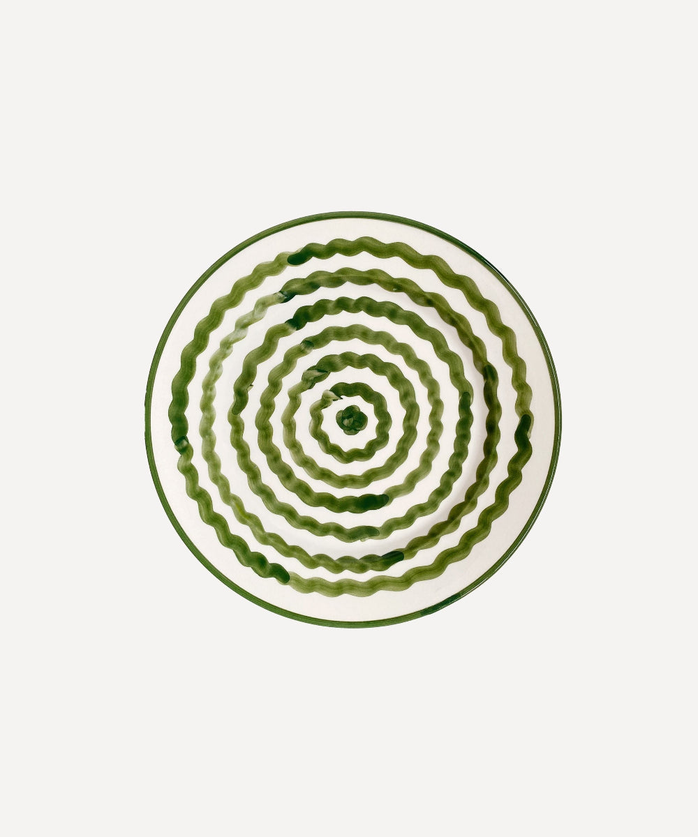 Decorative ceramic plate with concentric green patterns on a white background