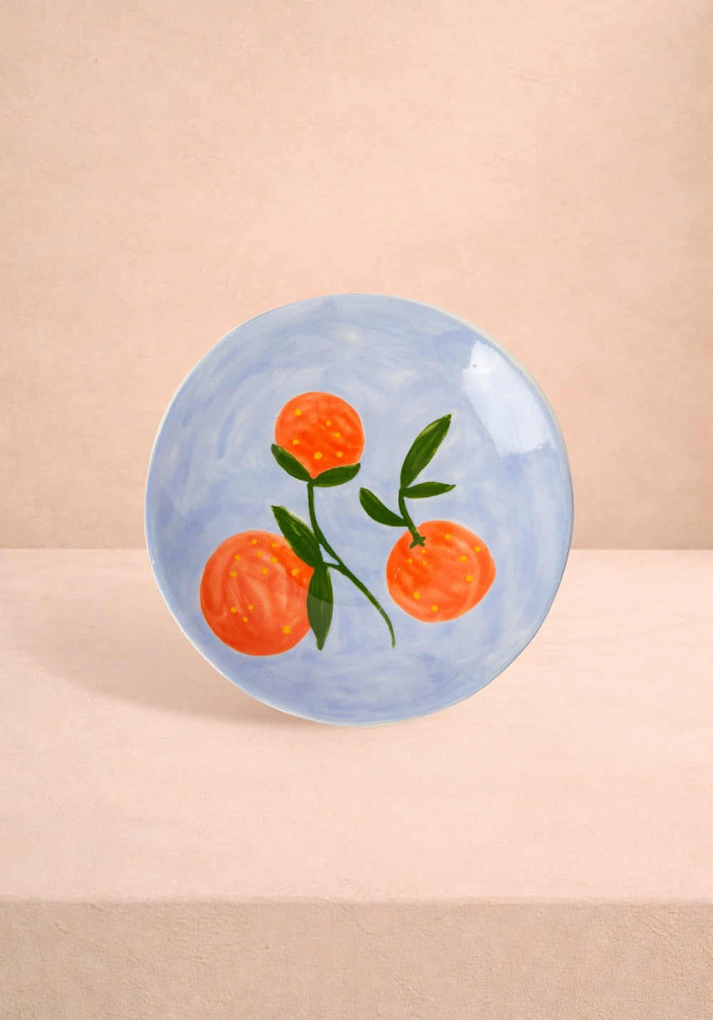 Decorative plate with orange fruit design on a beige background