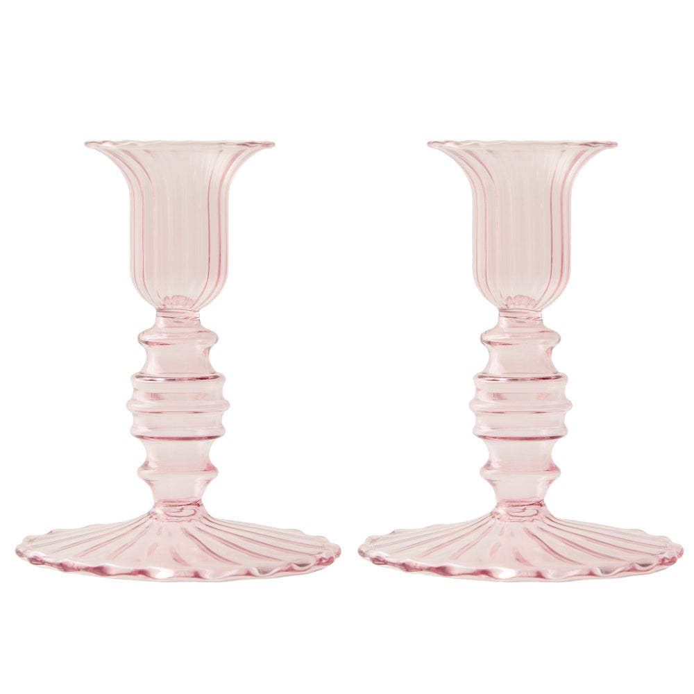 Two pink glass candle holders on a white background