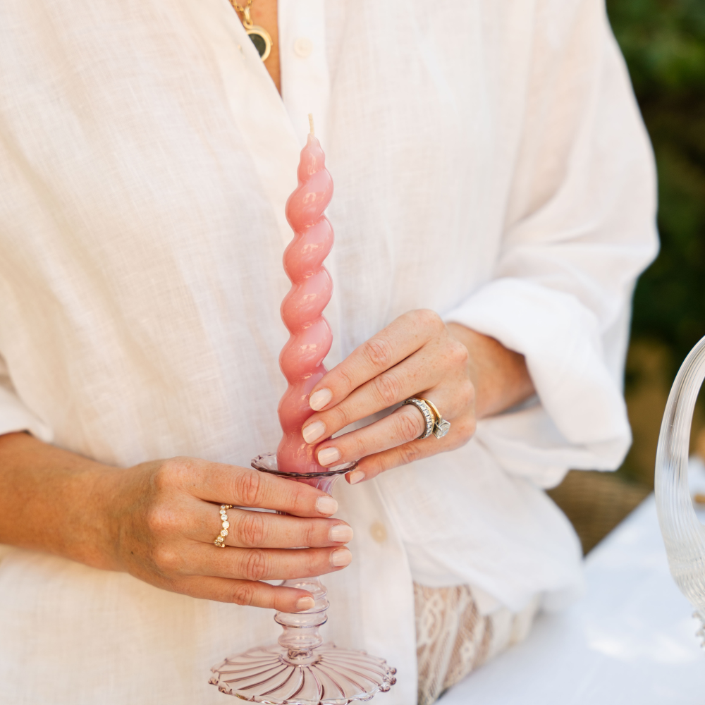 Person holding a pink glass with a white background