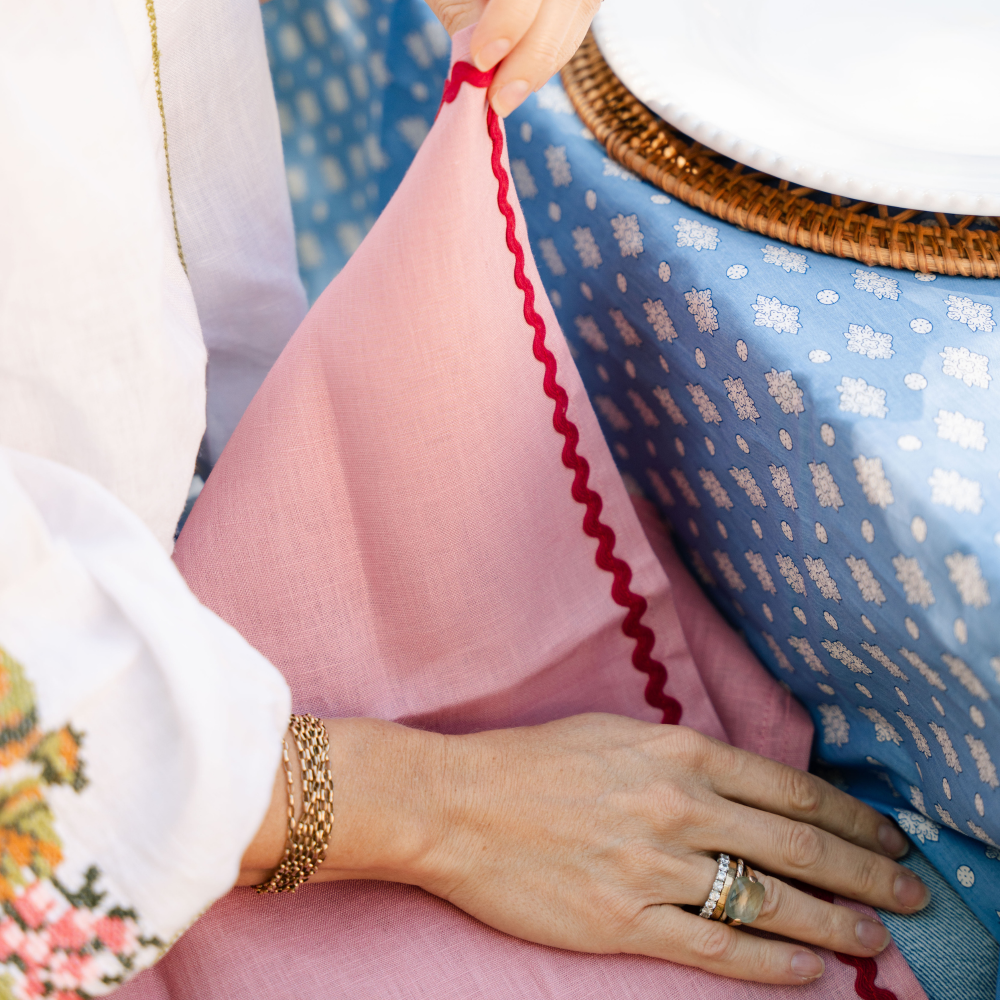 Close-up of a hand with rings with pink napkins in a garden background setting