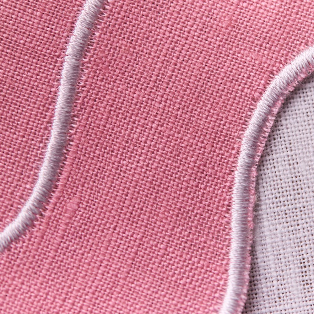 Close-up of pink fabric with embroidered edge