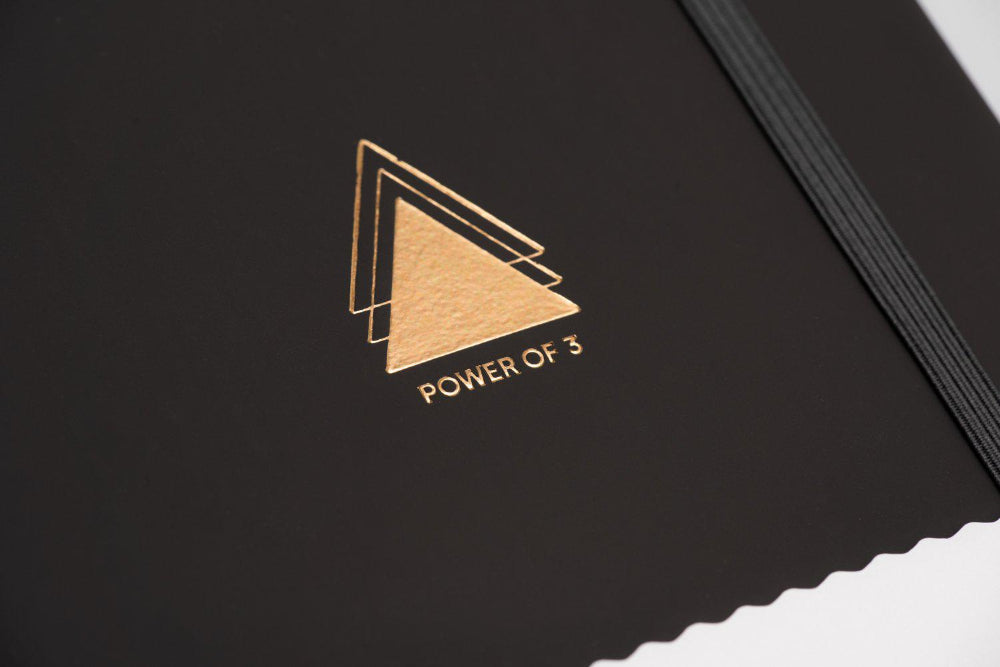 Power of three goal planner Yop and Tom Black book with gold geometric design and 'Power of 3' text