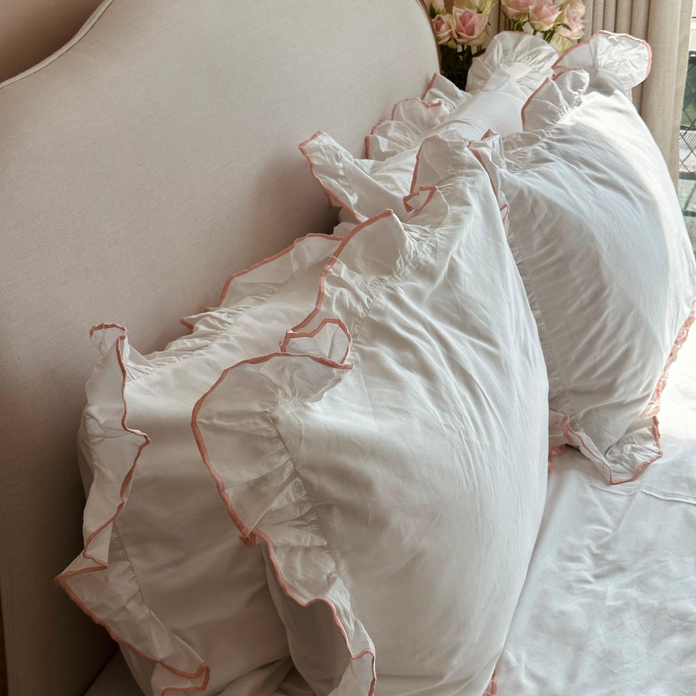 White pillows with ruffled edges on a bed