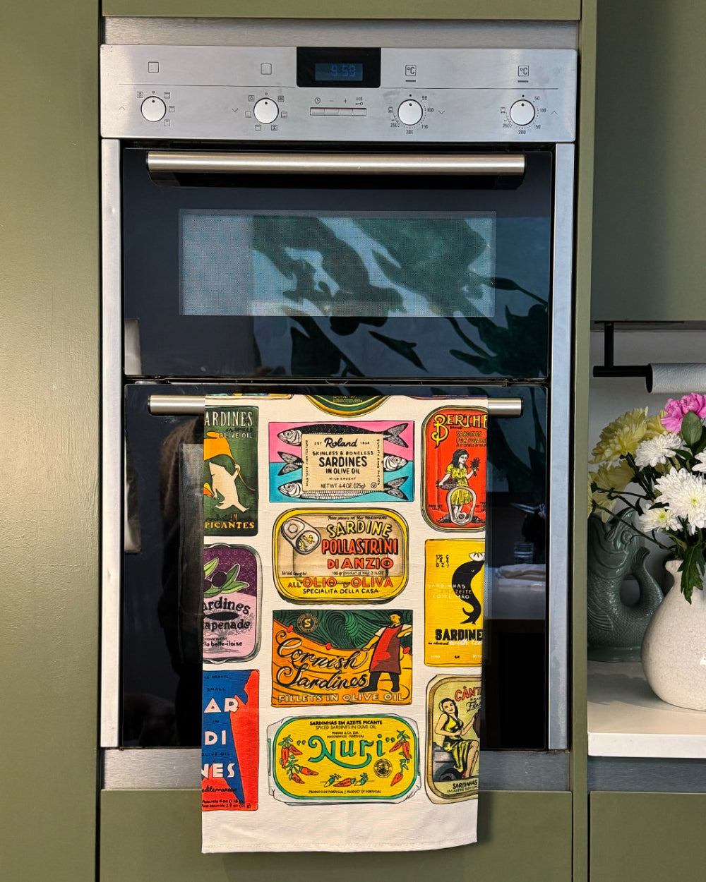 Stainless steel oven with decorative tea towel on a cooker