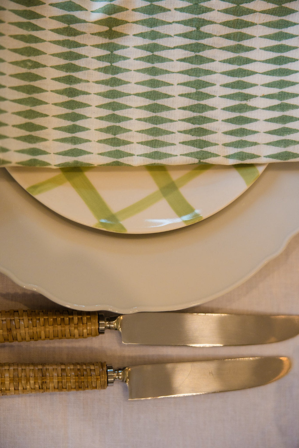 Set of gold cutlery on a green and white patterned napkin