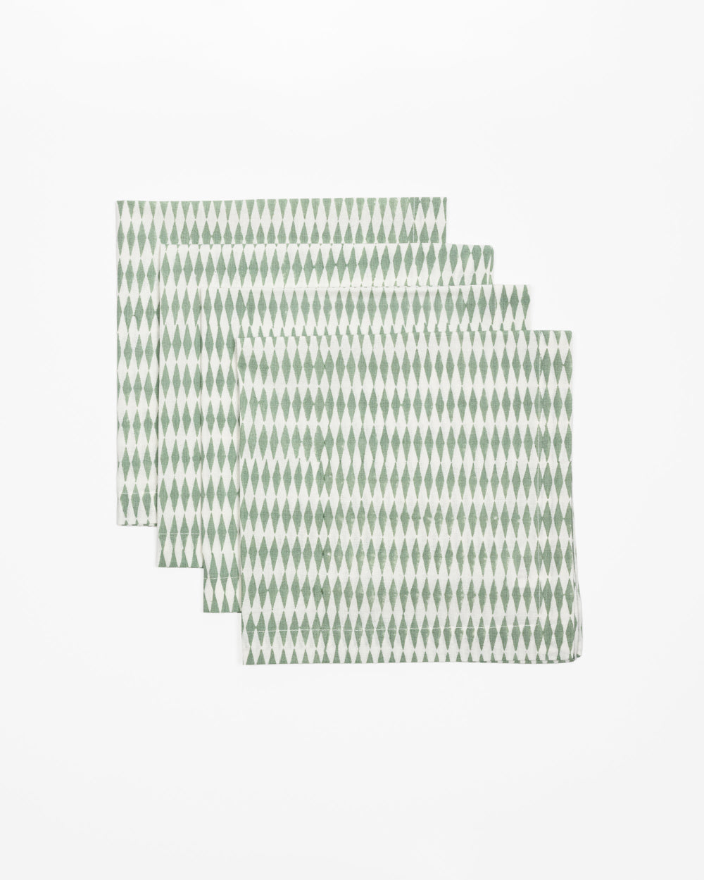 Set of four green patterned placemats on a white background
