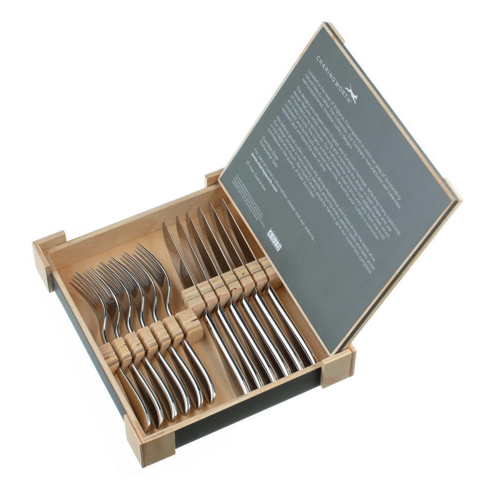 Set of silver forks  and knives in a wooden box with a grey cover on a white background
