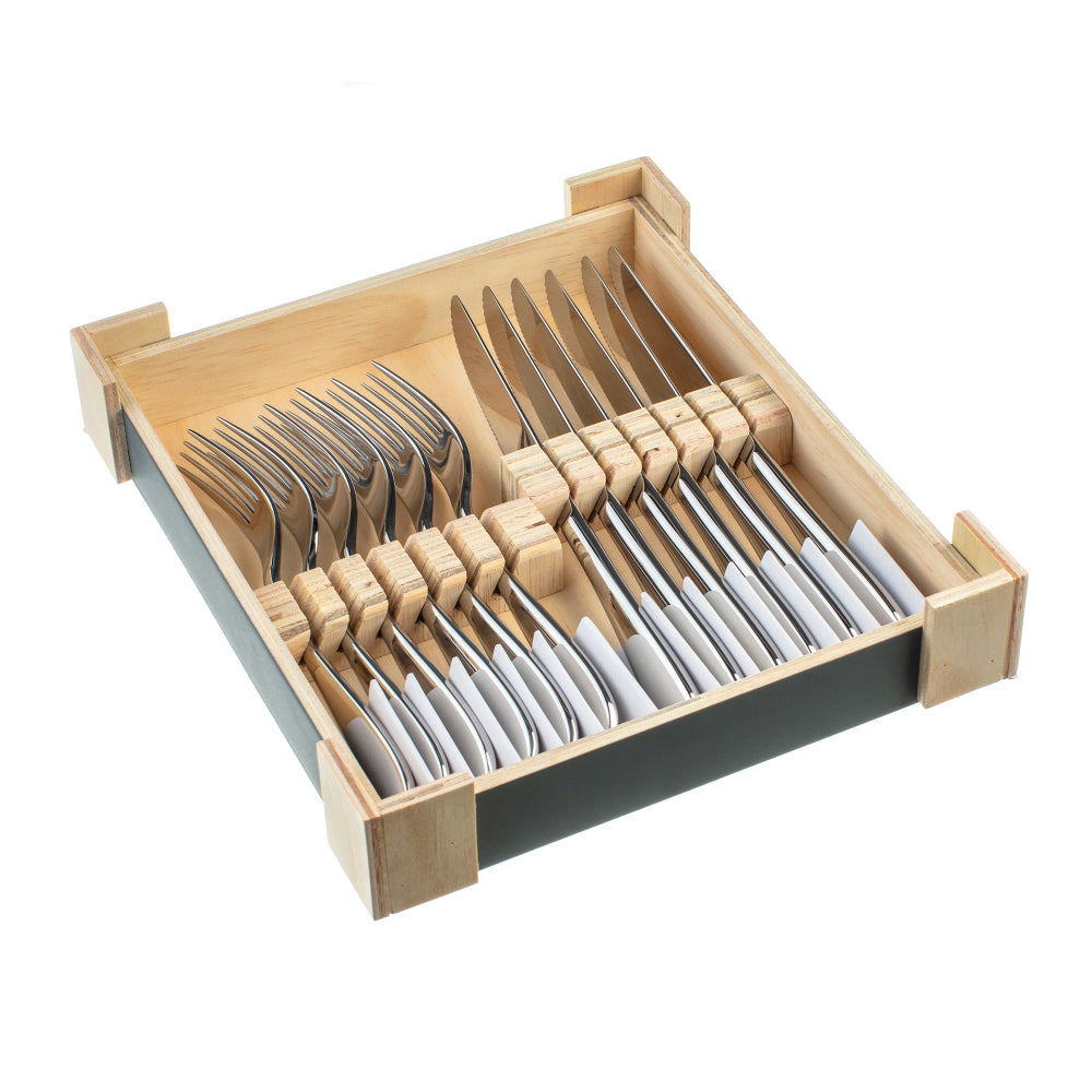 Set of silver cutlery in a wooden drawer organizer on a white background