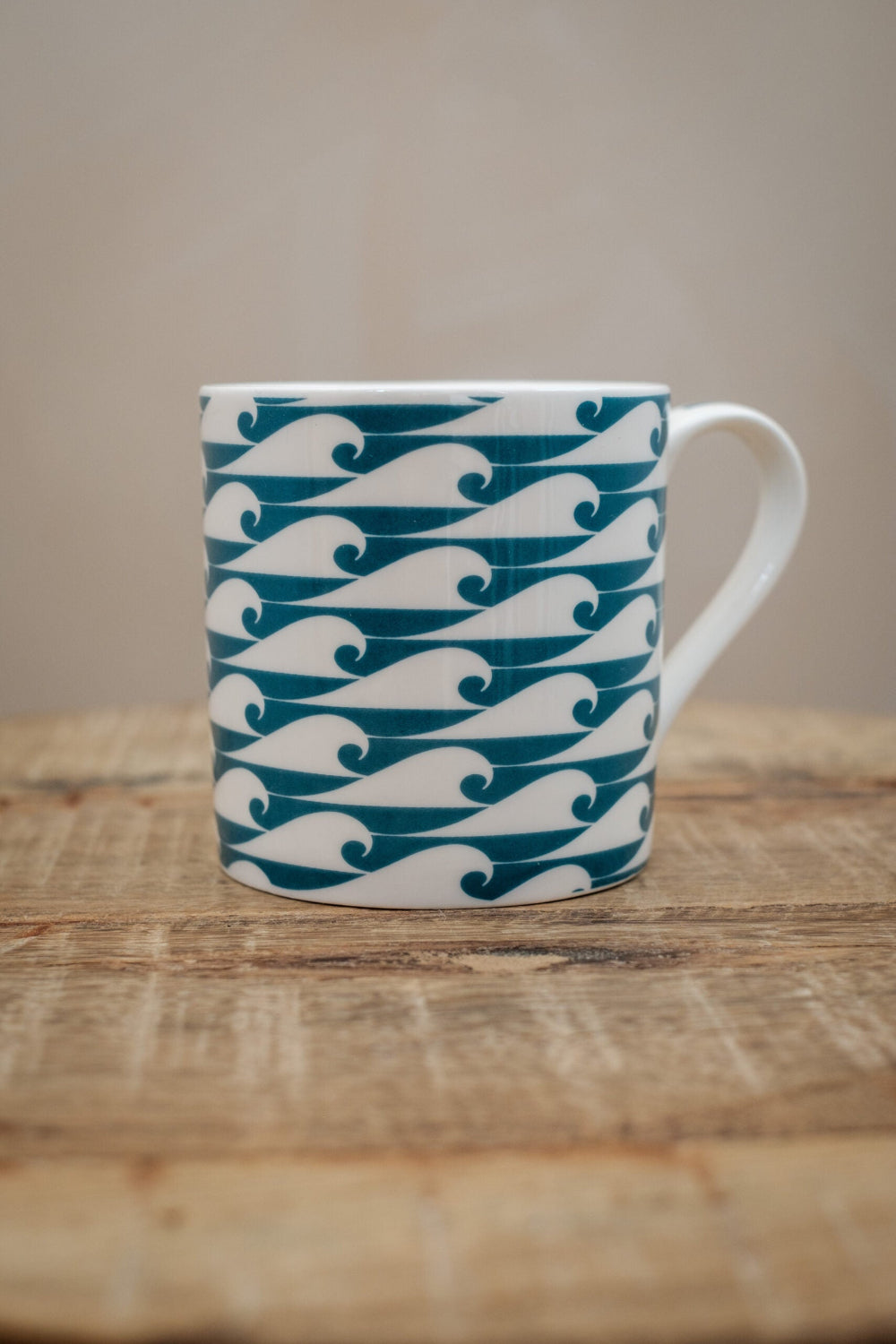 White mug with blue wave pattern on a wooden surface