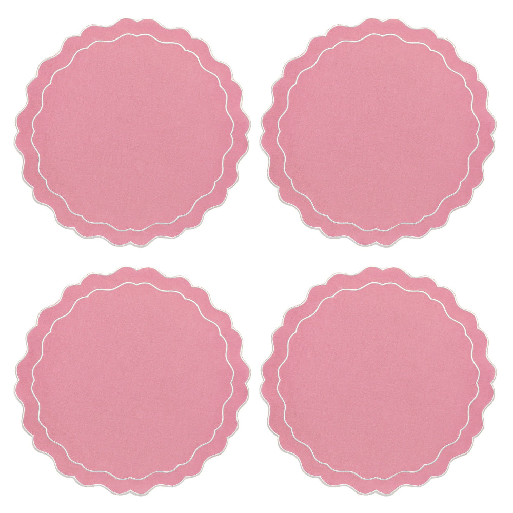 Four pink round paper plates with scalloped edges on a white background