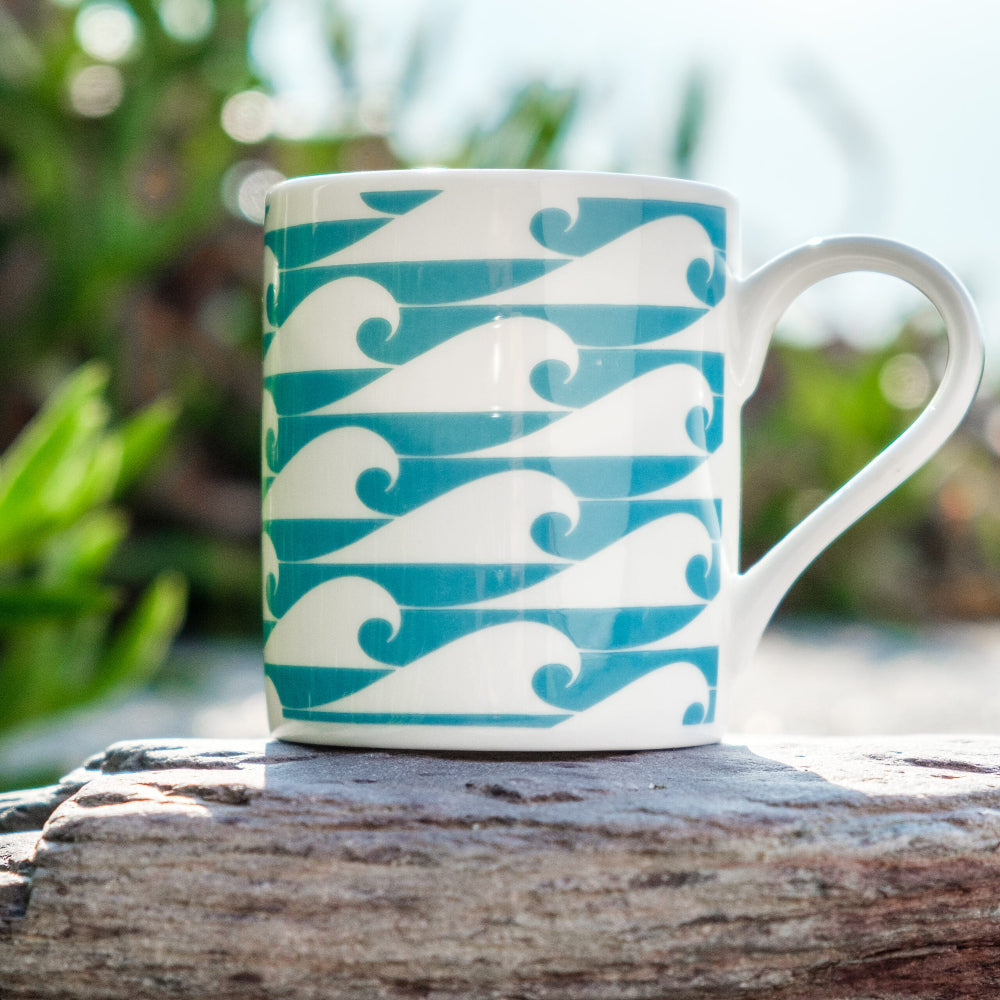 Espresso Cup with teal and white wave pattern on a wooden surface with a natural background