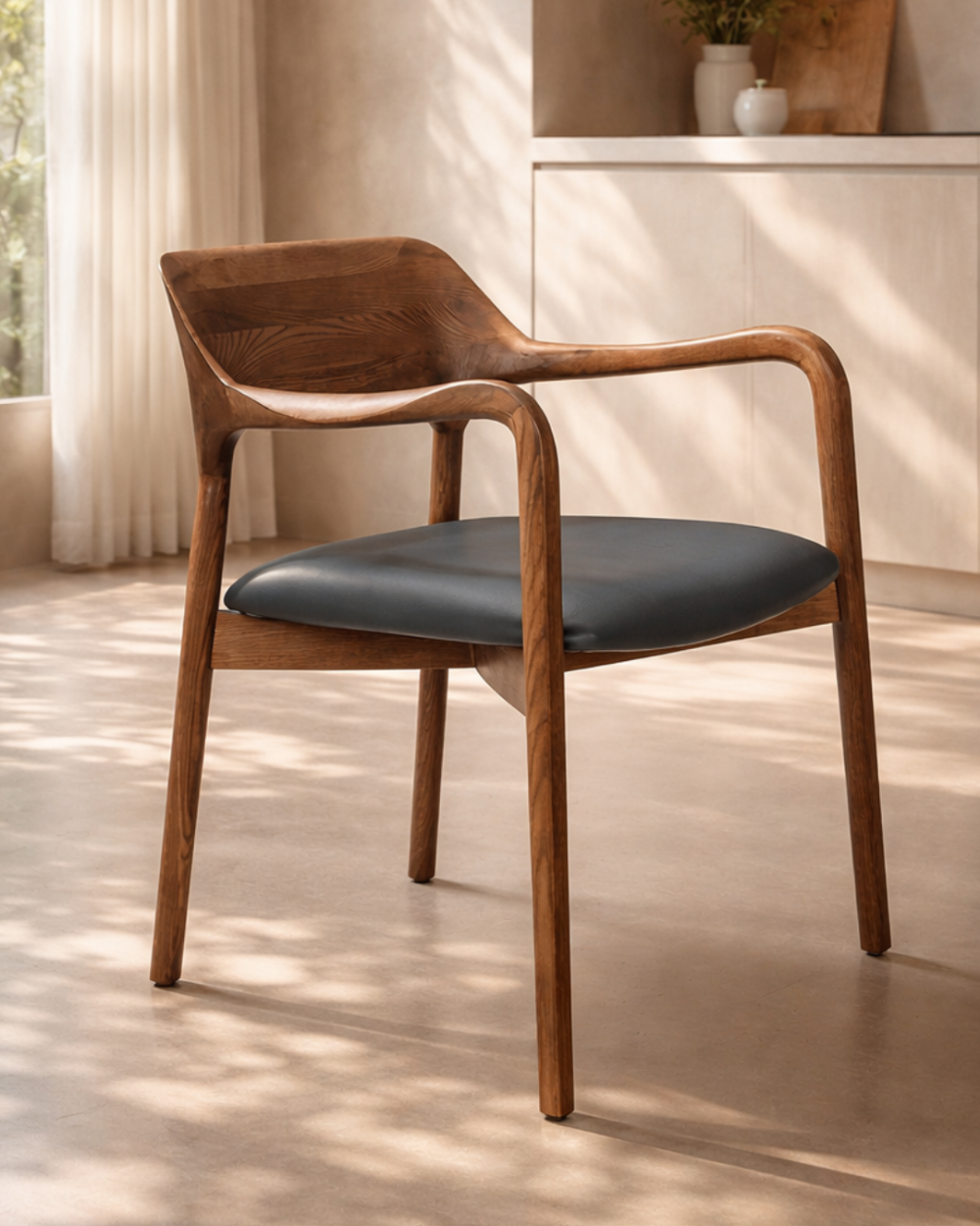 Wooden walnut dining chair with black seat in a room with light-coloured walls and floor.