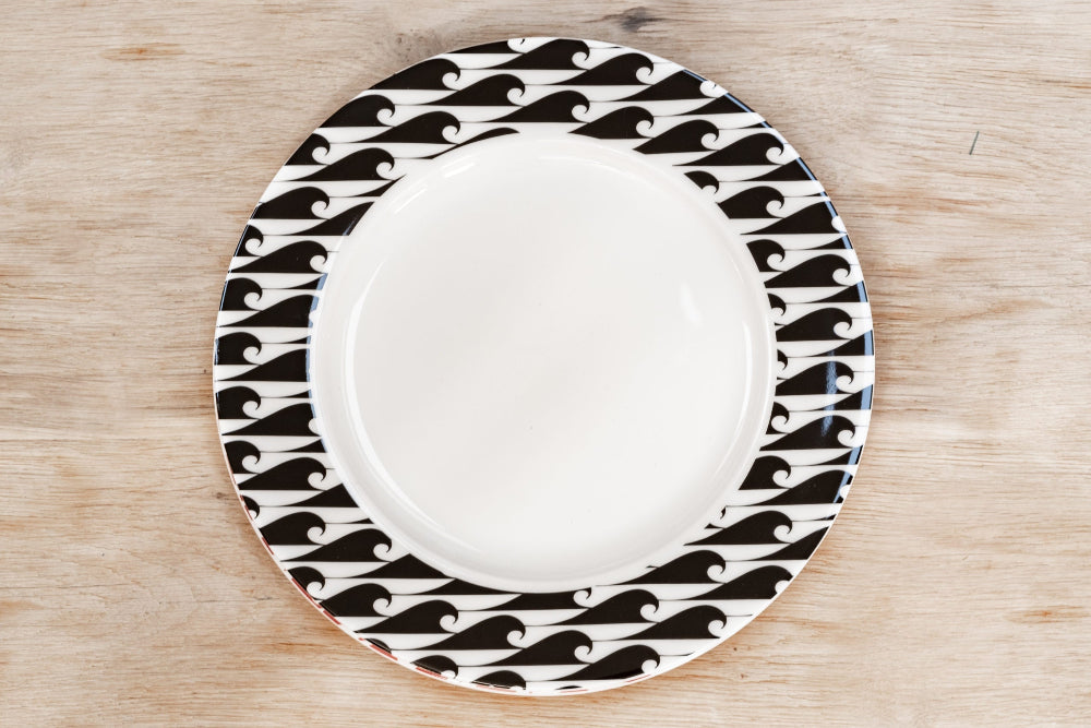 White plate with black geometric pattern on a wooden surface