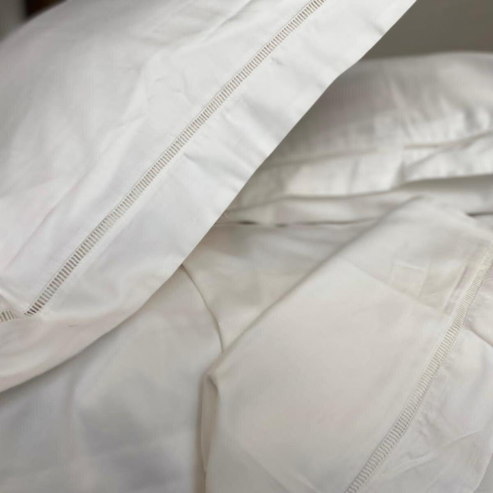 Sukun Close-up of white bedding with visible stitching details