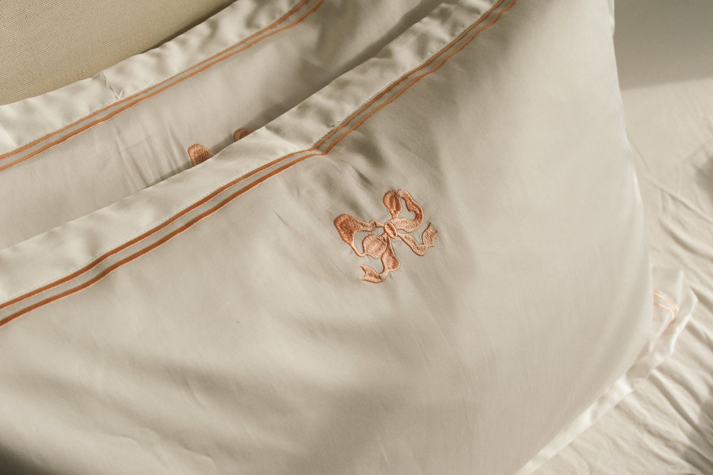 Close-up of Arabella Bow Oxford Pillowcases with a subtle pattern and embroidery detail.