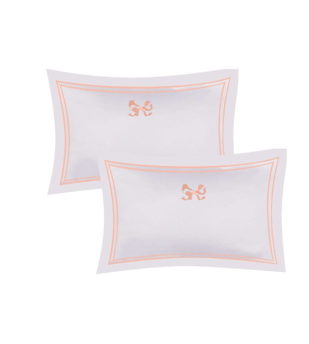 Two white pillows Arabella Bow Oxford Pillowcases with pink embroidery on a white background