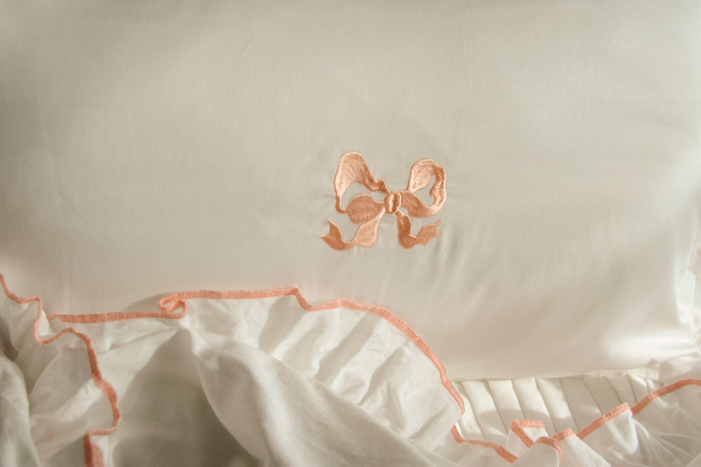 Close up of Peach Embroidered Bow on a ruffled frill pillowcase