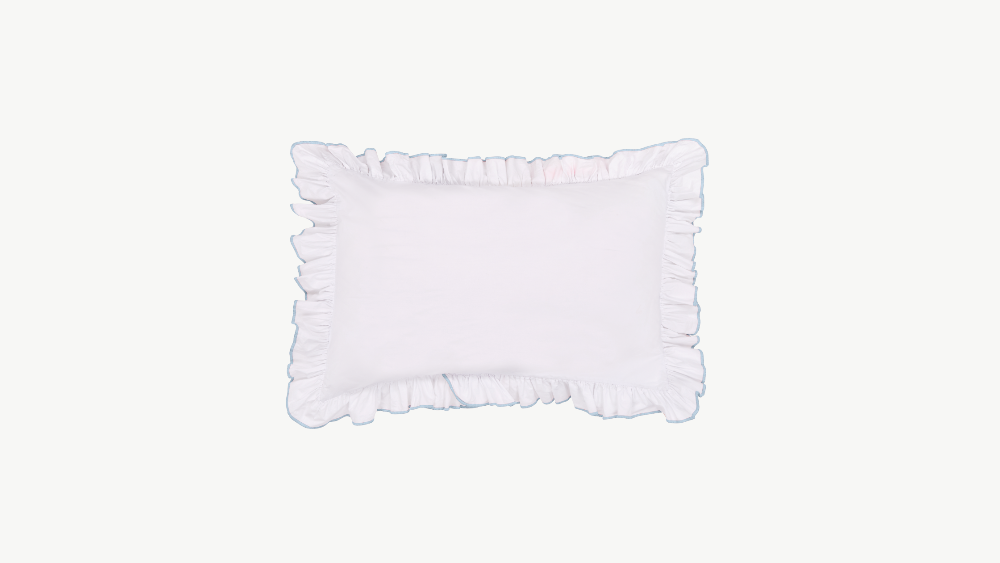 White pillowcase with ruffled edges on a light grey background