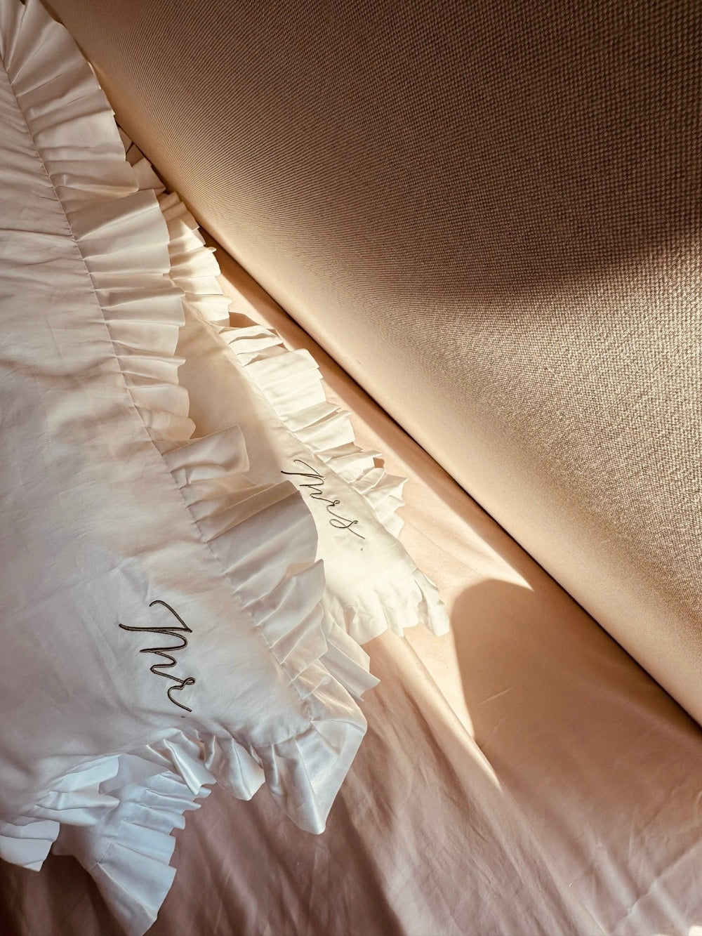 Close-up of pillows with ruffled edge and "mR & "mRS" Embroidery