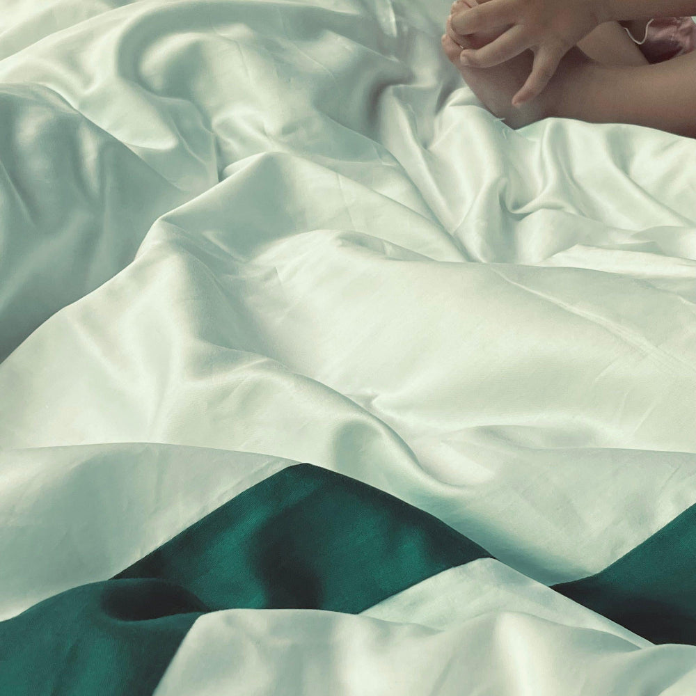 Close-up of a person lying on a bed with white bedding