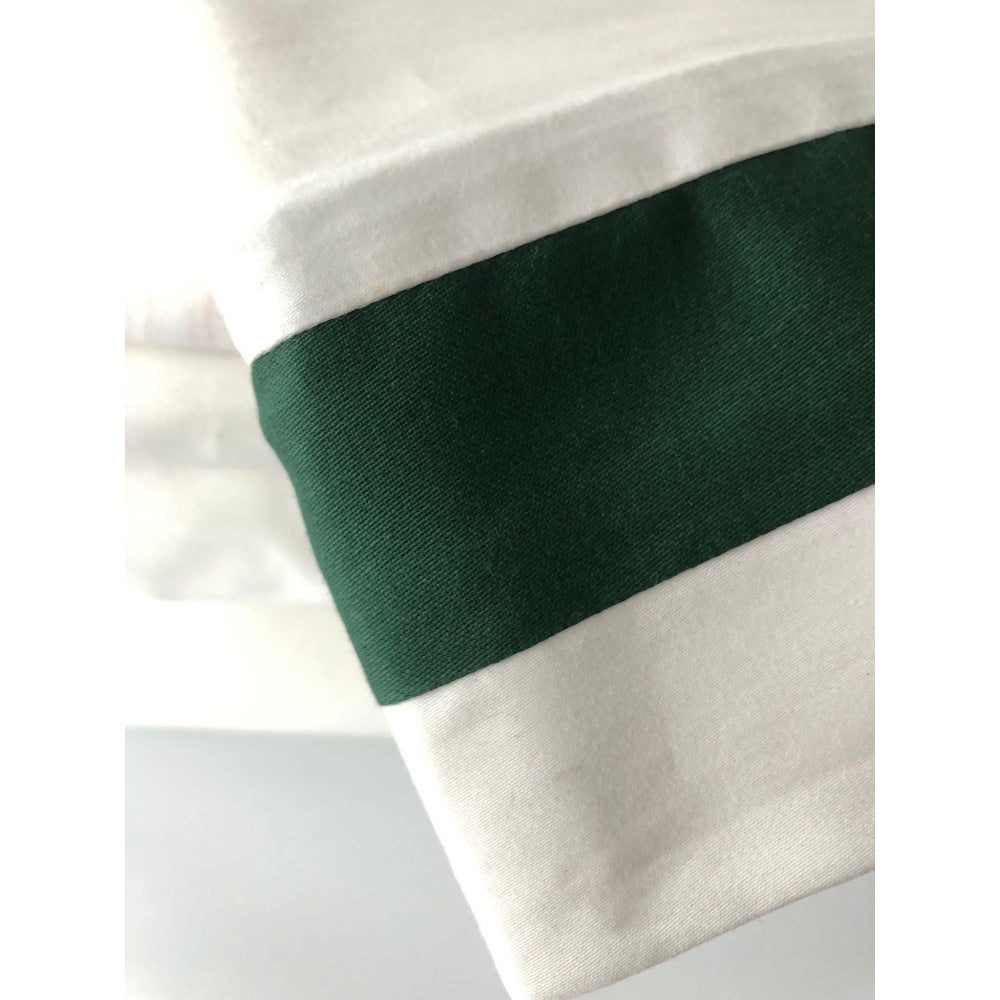 Close-up of a white fabric with a green band on a light grey background