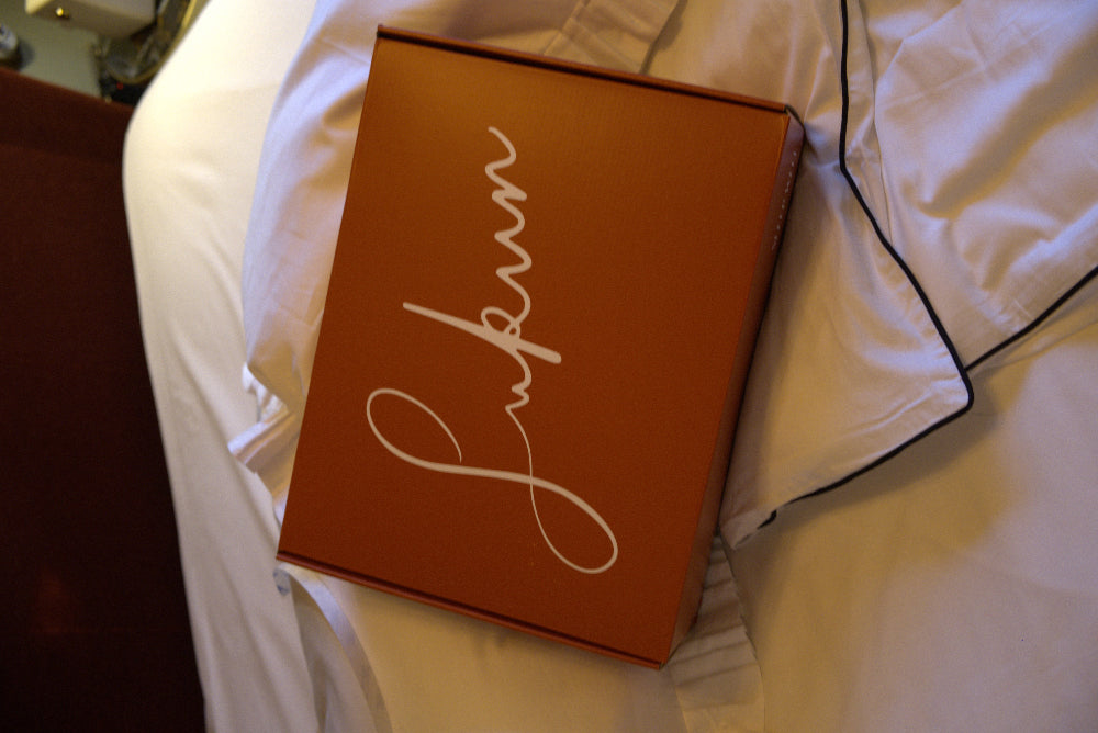 Brown box with 'Sukun' branding on a white bedspread
