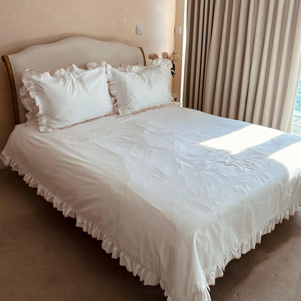 Bed with white ruffled bedding in a bedroom setting