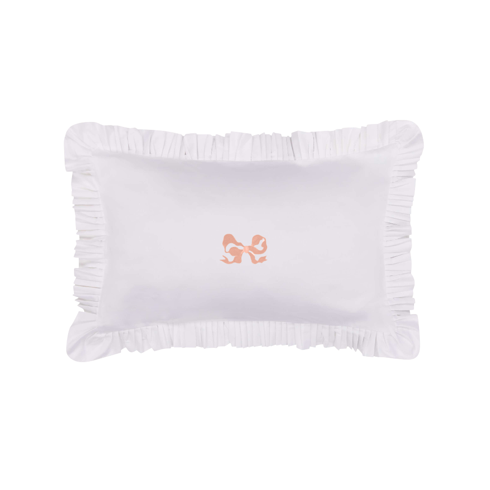 White pillow with ruffled edge and orange embroidered bow on a white background