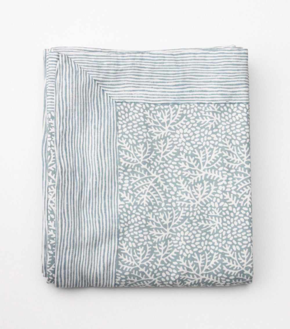 Folded Blue Cotton Tablecloth with a pattern on a white background