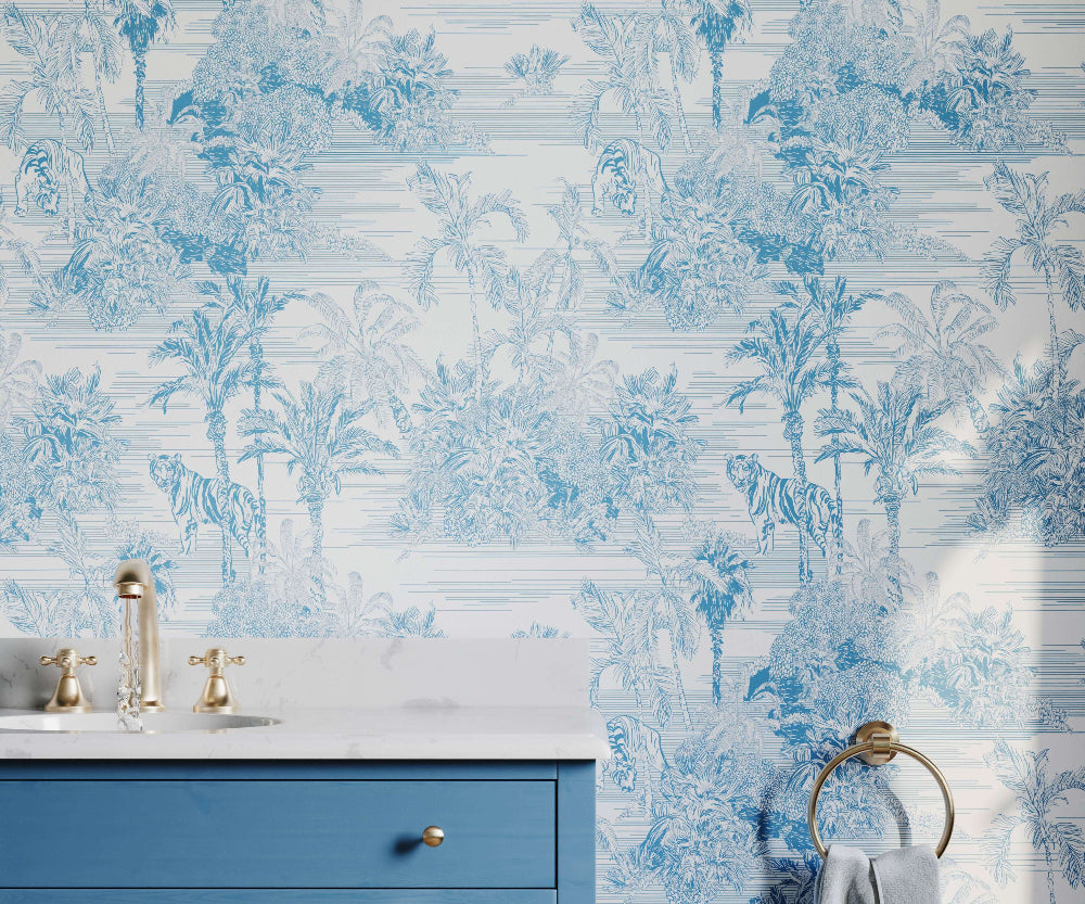 Bathroom with blue and white floral wallpaper, blue vanity, and gold fixtures.