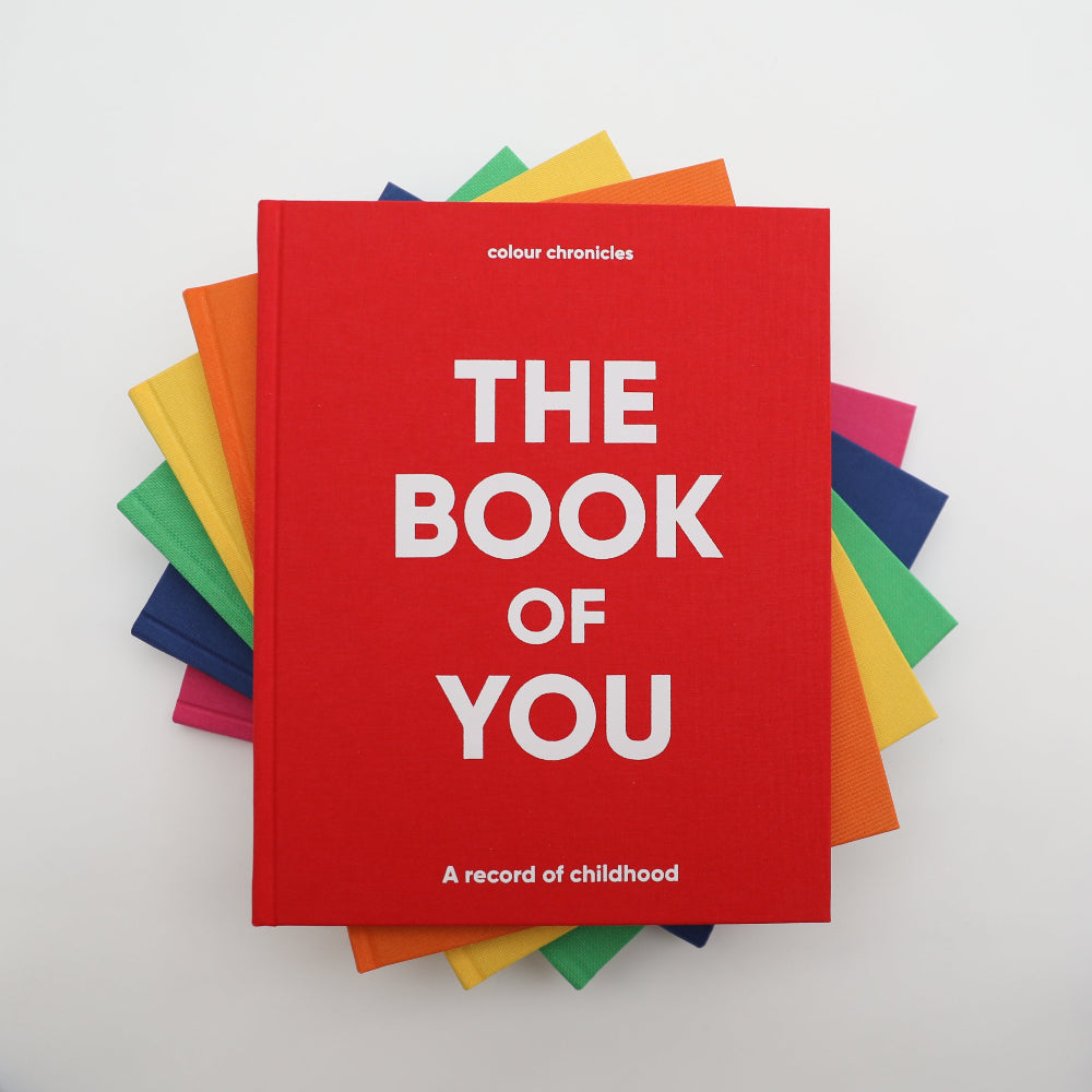 Red book titled 'The Book of You' with colorful covers on a white background