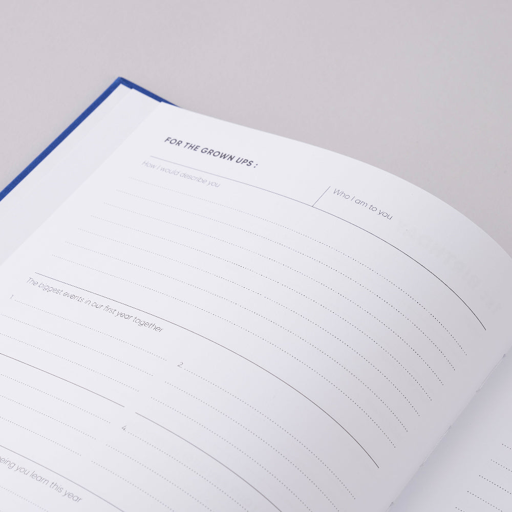 The book of you a record of childhood Open notebook with lined pages on a light grey background