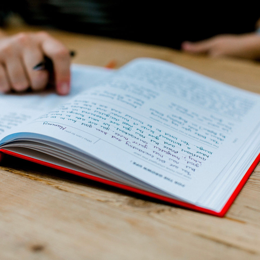 The book of you Open book with handwritten notes on a wooden table