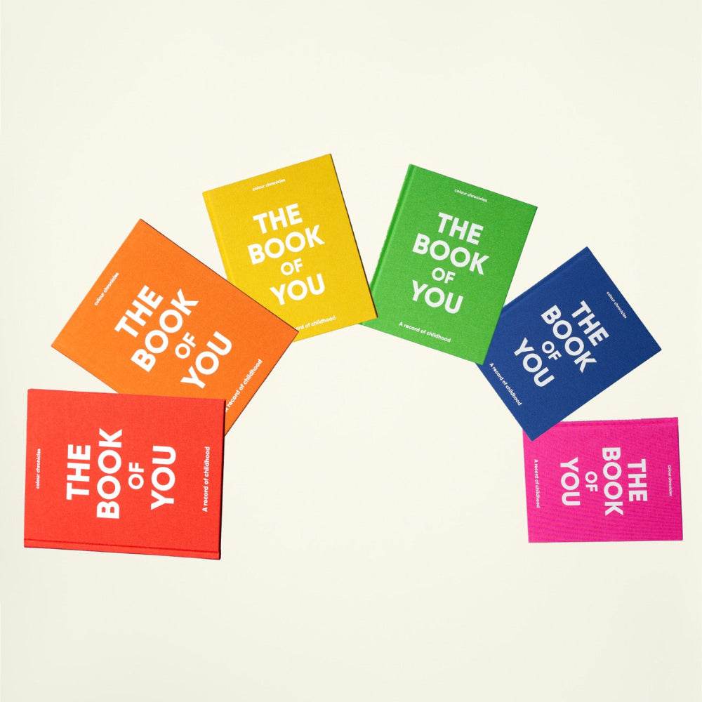 Colourful books titled 'The Book of You' on a beige background