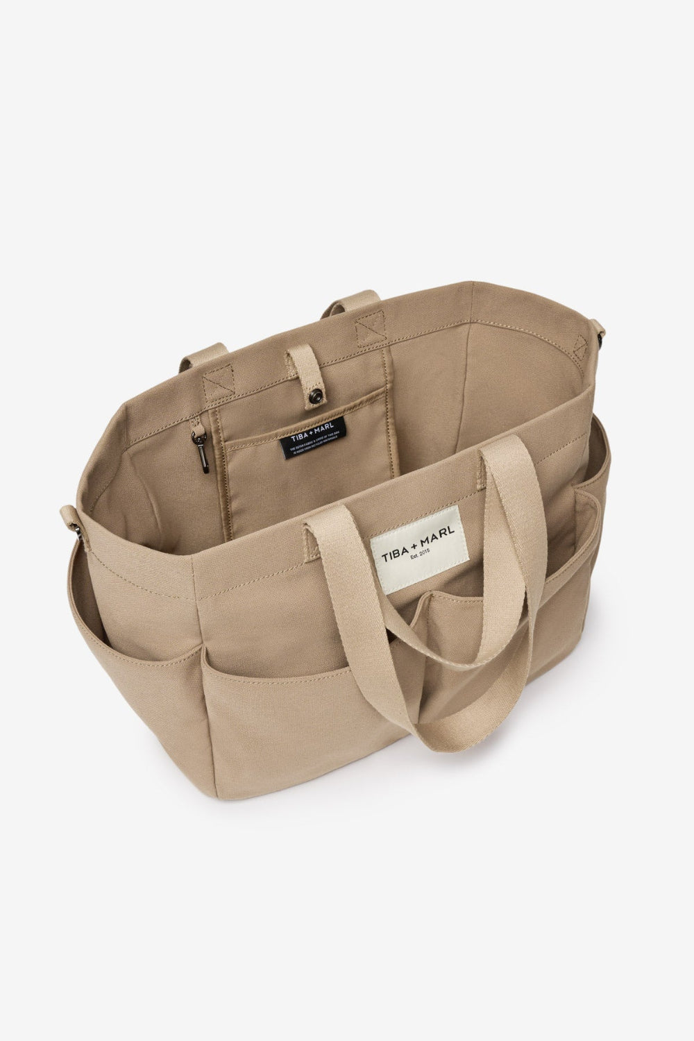 Beige tote bag with multiple compartments on a white background