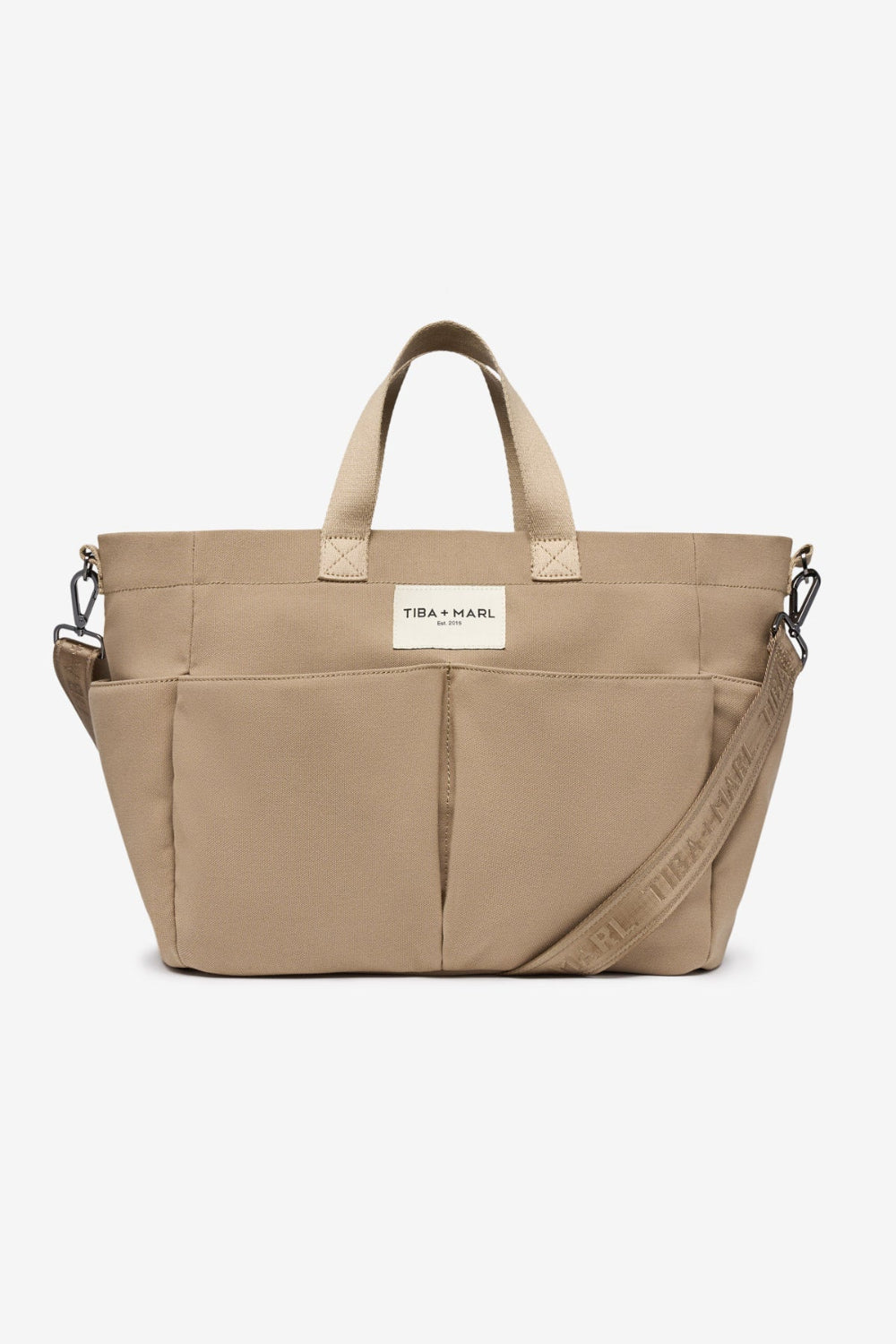 Beige tote bag with a visible brand label Tiba + Marl on a white background